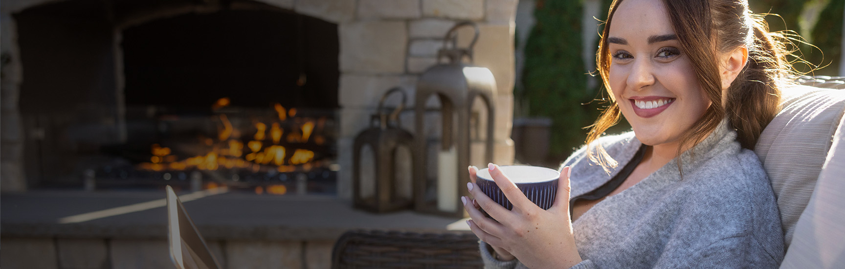 women sitting near fire with a cup