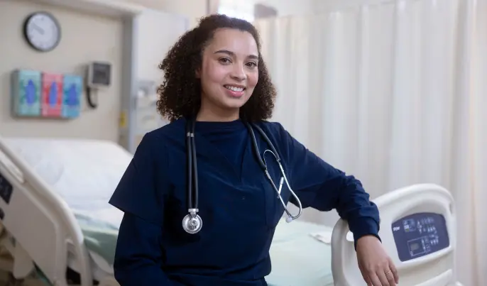 Women smiling at camera leaning on bed