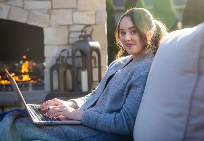 Women with laptop in front of fire