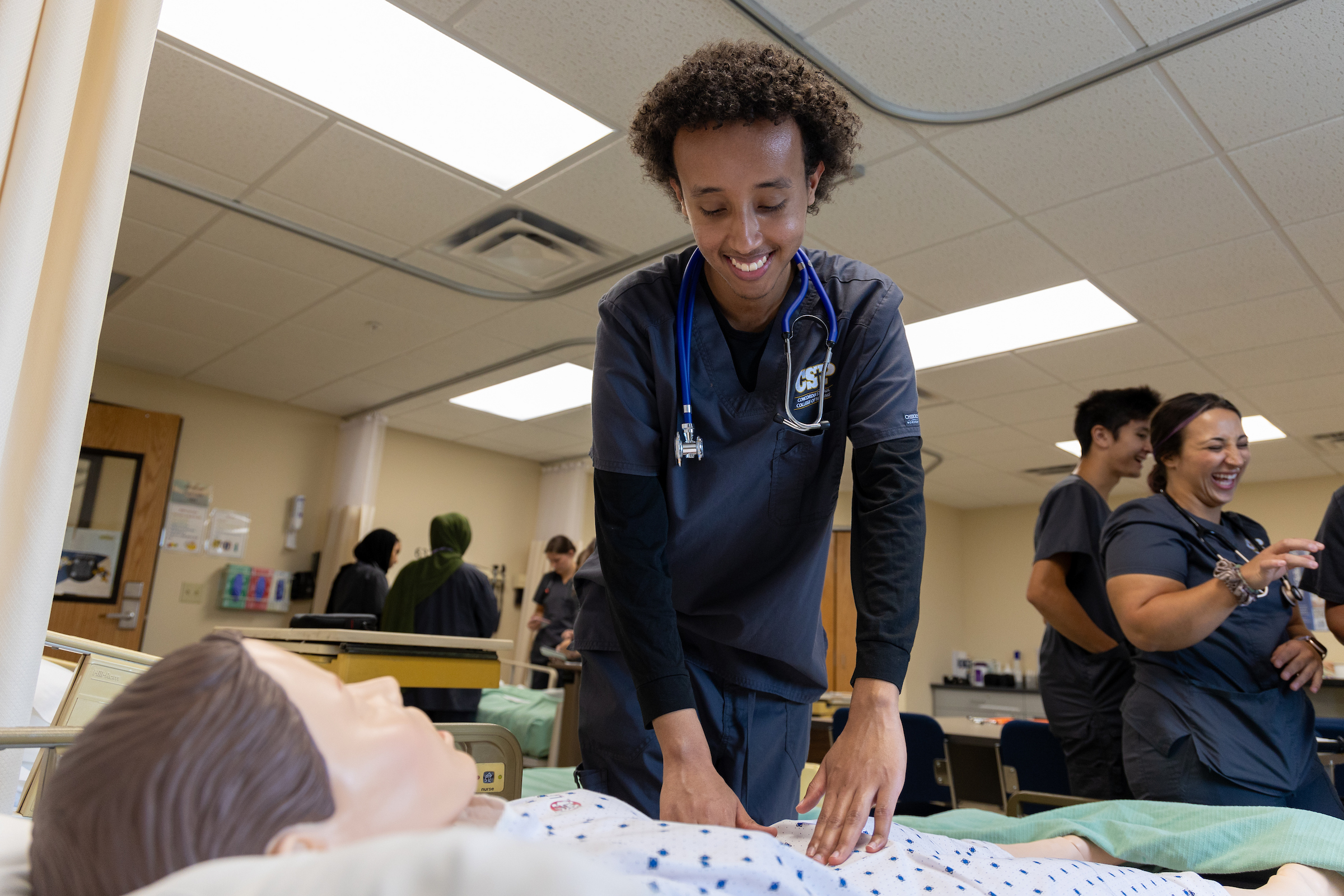 Nursing student practicing on a simulation in a lab setting.